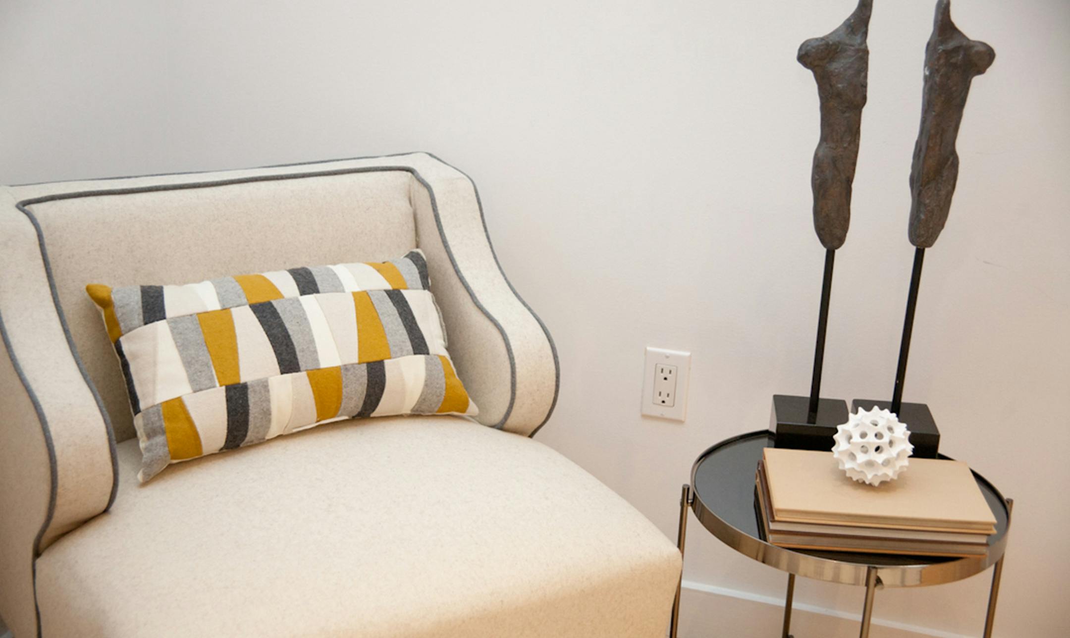A chartreuse and gray toss pillow highlights a beige arm chair. (Handout/TNS) ORG XMIT: 1186220