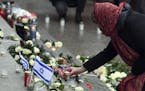 Pedestrians place flowers, pictures and candles after the opening of a memorial site in Berlin, Germany, Tuesday, Dec. 19, 2017 to honor the victims o
