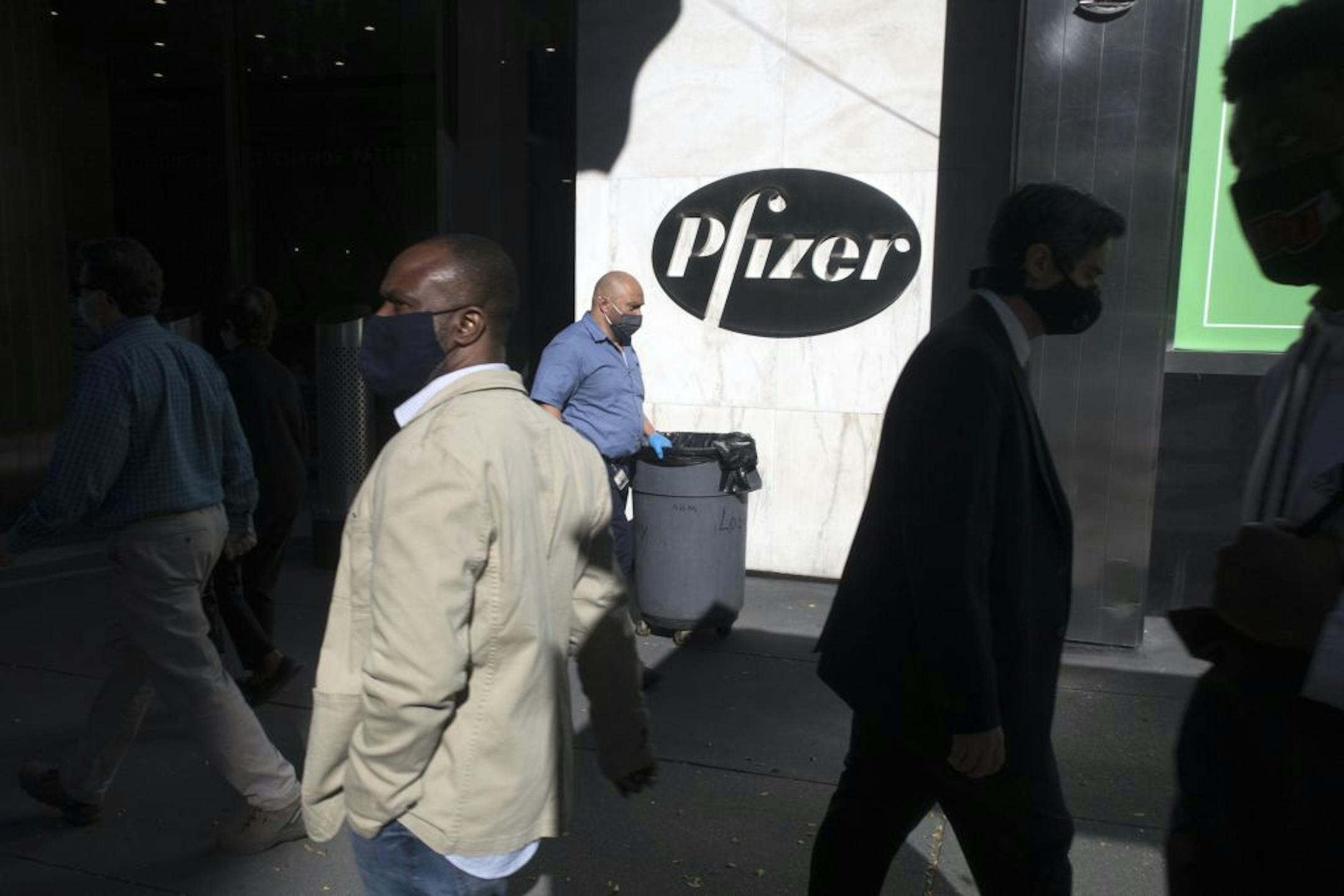 Pedestrians passed by the Pfizer world headquarters, Monday, Nov. 9, 2020, in New York.