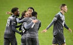 Teammates, including Minnesota United defender Romain Metanire (19) and midfielder Kevin Molino (7), celebrated with midfielder Ethan Finlay (13), sec