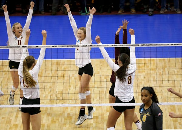 University of Minnesota players celebrate their team's 3 sets to 1 victory over the University of Missouri during the regional NCAA volleyball tournam