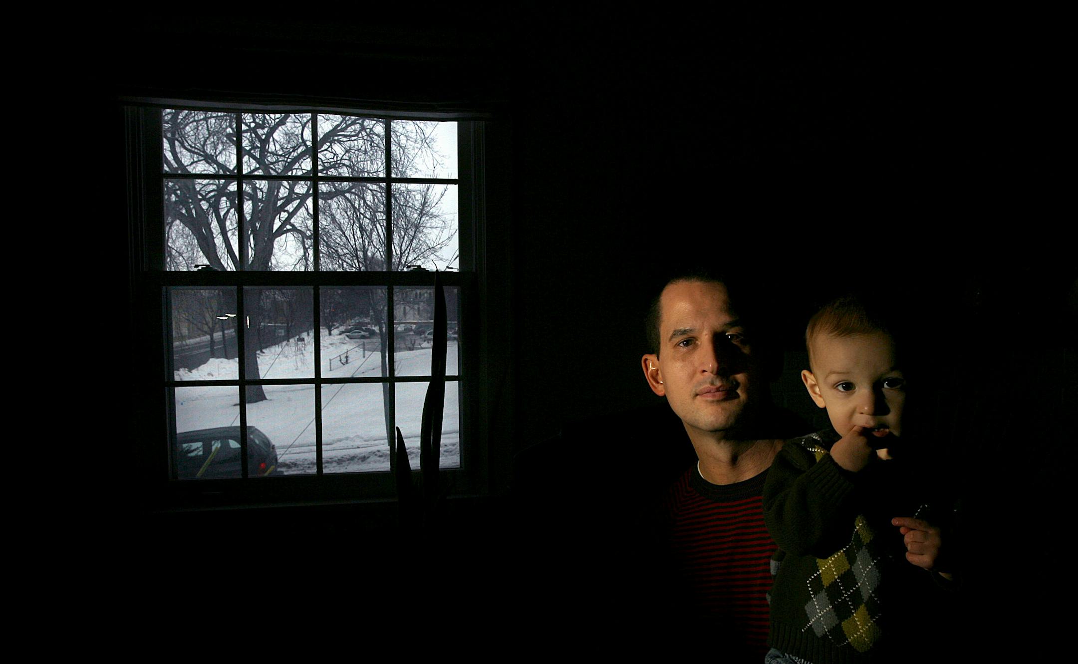 Harry Kaiser, holding 15-month-old son Joey, and other neighbors are concerned about an affordable-housing apartment building planned for a back lot of Mayflower Community Congregational Church, across the street from his house in south Minneapolis. The oak tree in the background likely will be cut down.