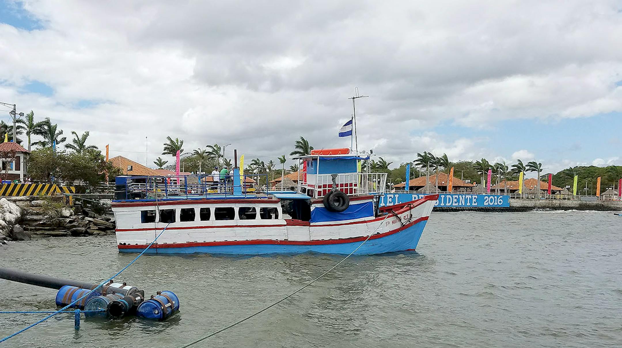 A ferry boat in Lake Nicaragua at the port of San Jorge in March 2017 obscures a 2016 re-election banner for President Daniel Ortega.
