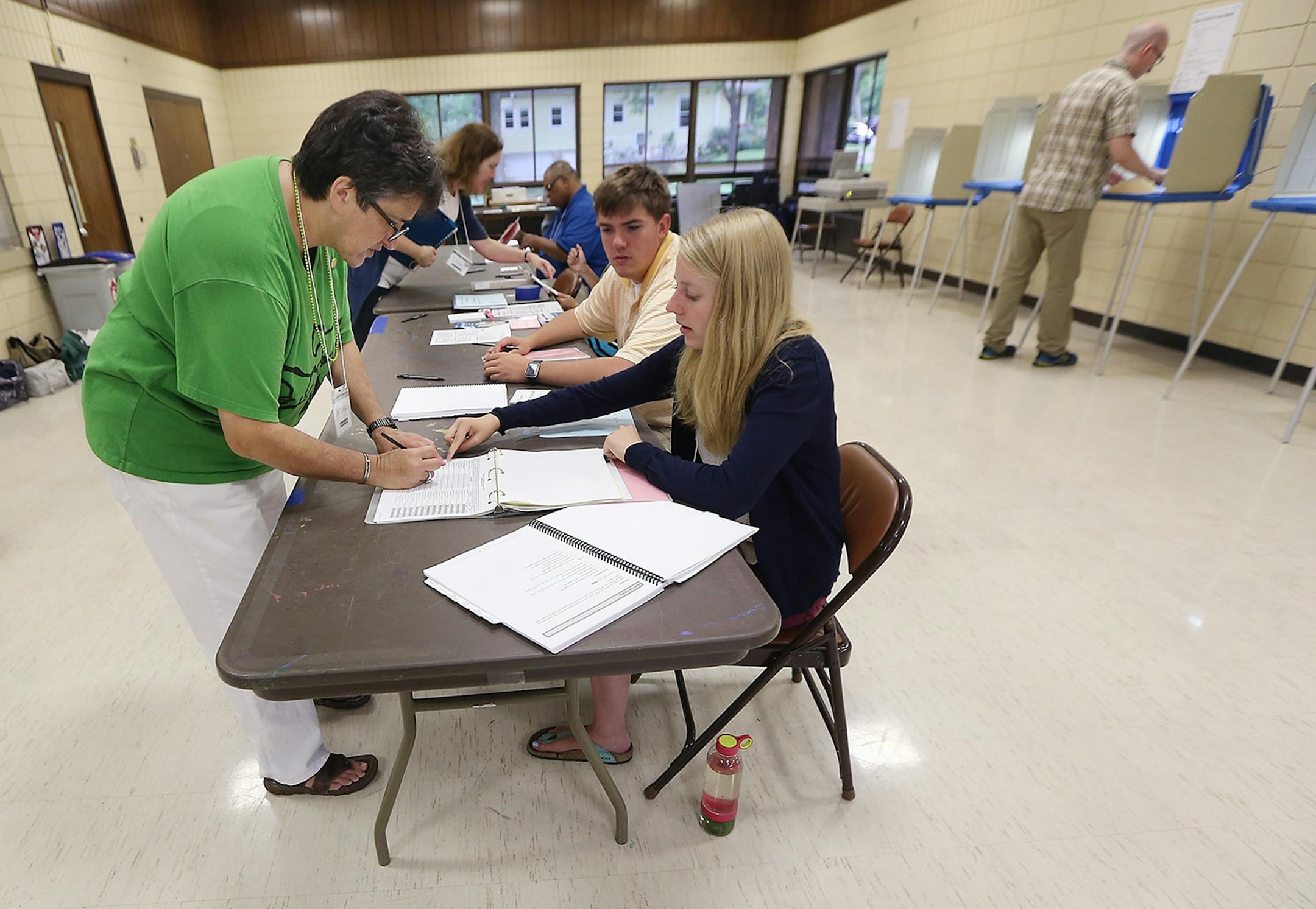 Natasha Vaubel, left, got the help of election official Margot Graham before casting her ballot at the Linden Hills Park Recreation Center, Tuesday, August 9, 2016 in Minneapolis, MN.