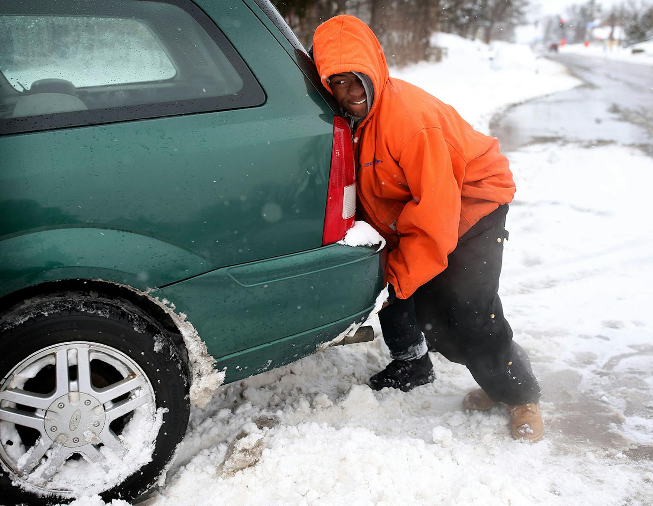 Lequient Travis pushed a car out of the snow on Penn Avenue Sunday April 15, 2018 in Minneapolis, MN.