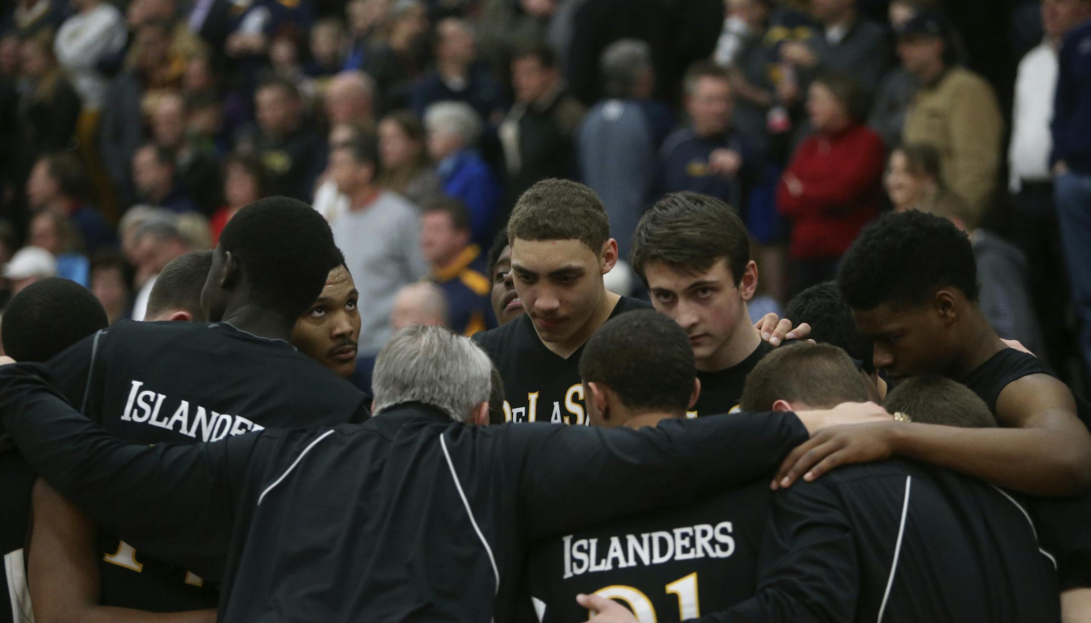 DeLaSalle coach Dave Thorson, front center, huddled with his players last week after the two-time defending state champion defeated Totino-Grace for another trip to the Class 3A boys' basketball tournament.