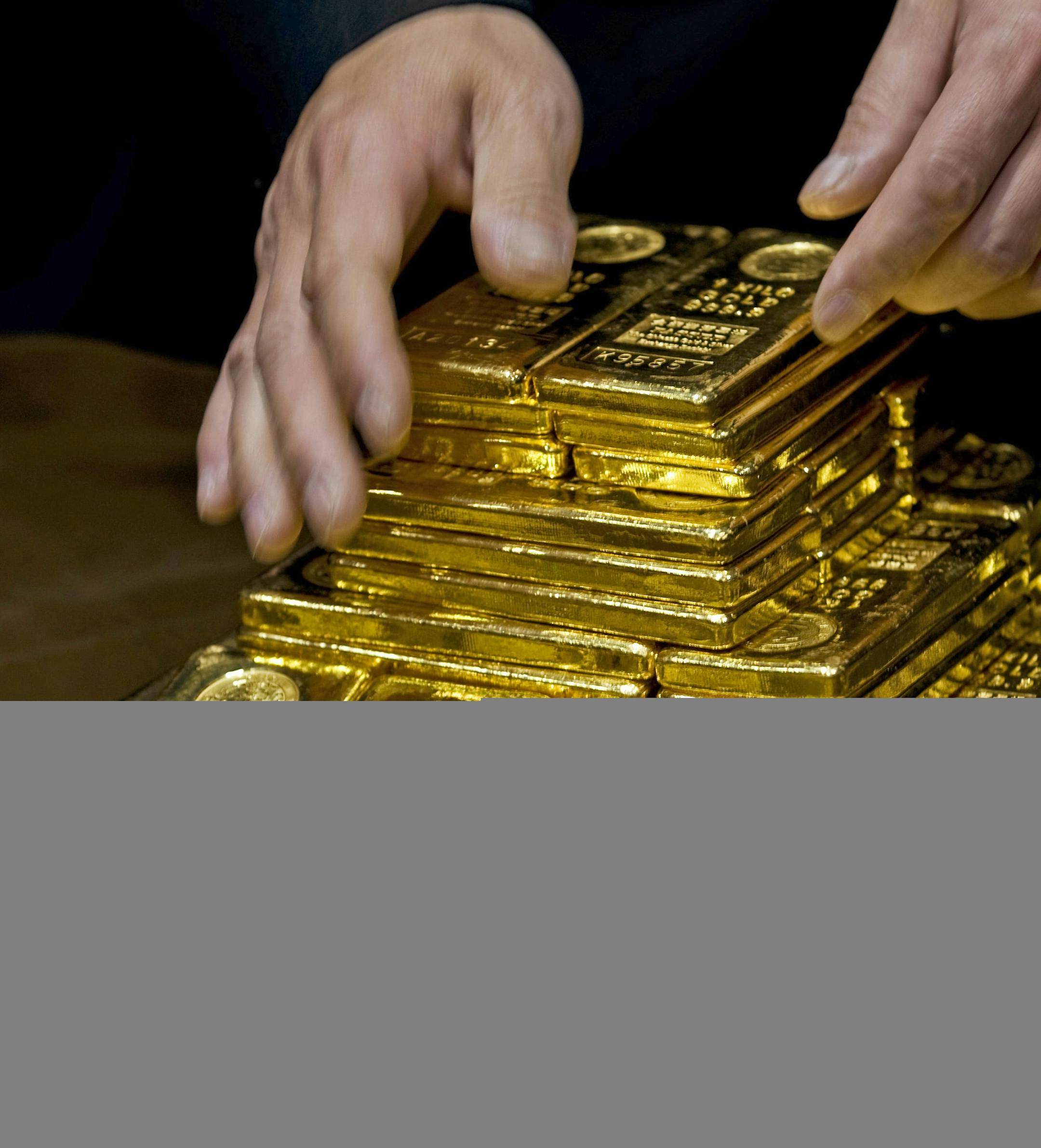 In an Oct. 17, 2011, file photo a staff member displays gold bullion bars during a news conference at the Chinese Gold and Silver Exchange Society in Hong Kong. A new study based on observations from space suggests the gold on Earth came from colliding dead stars in a cataclysmic event that occurred long ago. The research by the Harvard-Smithsonian Center for Astrophysics will appear in a future issue of the Astrophysical Journal Letters. (AP Photo, File)