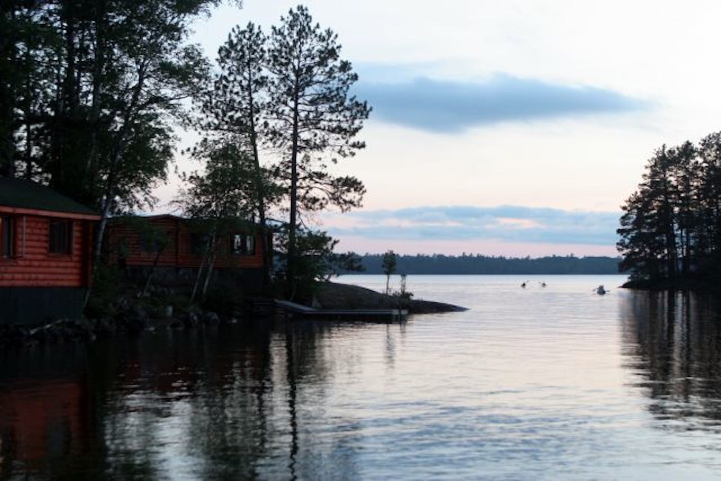 Calm prevails at Burntside Lodge, especially during evenings. Lights from Cabin Two, near the sauna and a swimming beach, reflect off the lake. Cabin One occupies a rock outcropping nearby.