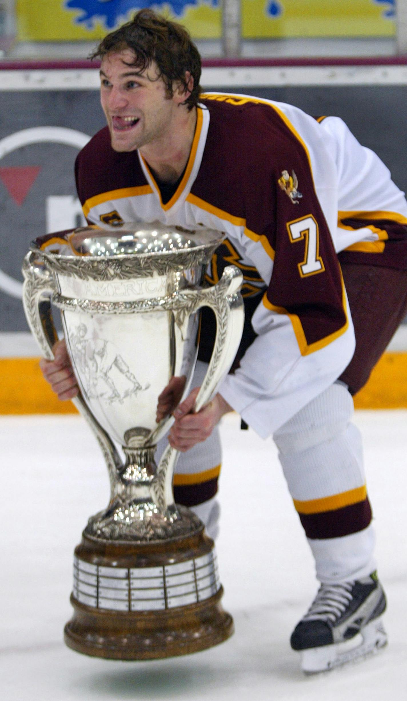 BRUCE BISPING &#xd4; bbisping@startribune.com Bruce Bisping/Star Tribune. Minneapolis, MN., Friday, 3/3/2006. (left to right) Gopher Captain Gino Guyer picked up the heavy WCHA MacNaughton cup after it was presented by commissioner Bruce McLeod at the end of the Gopher game against Minnesota Duluth. ORG XMIT: MIN2013030717382570