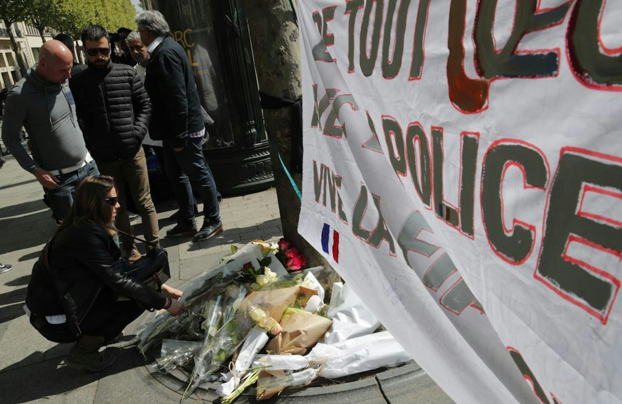 A woman places flowers at the place where a police officer was killed Thursday on the Champs Elysees boulevard on Friday.