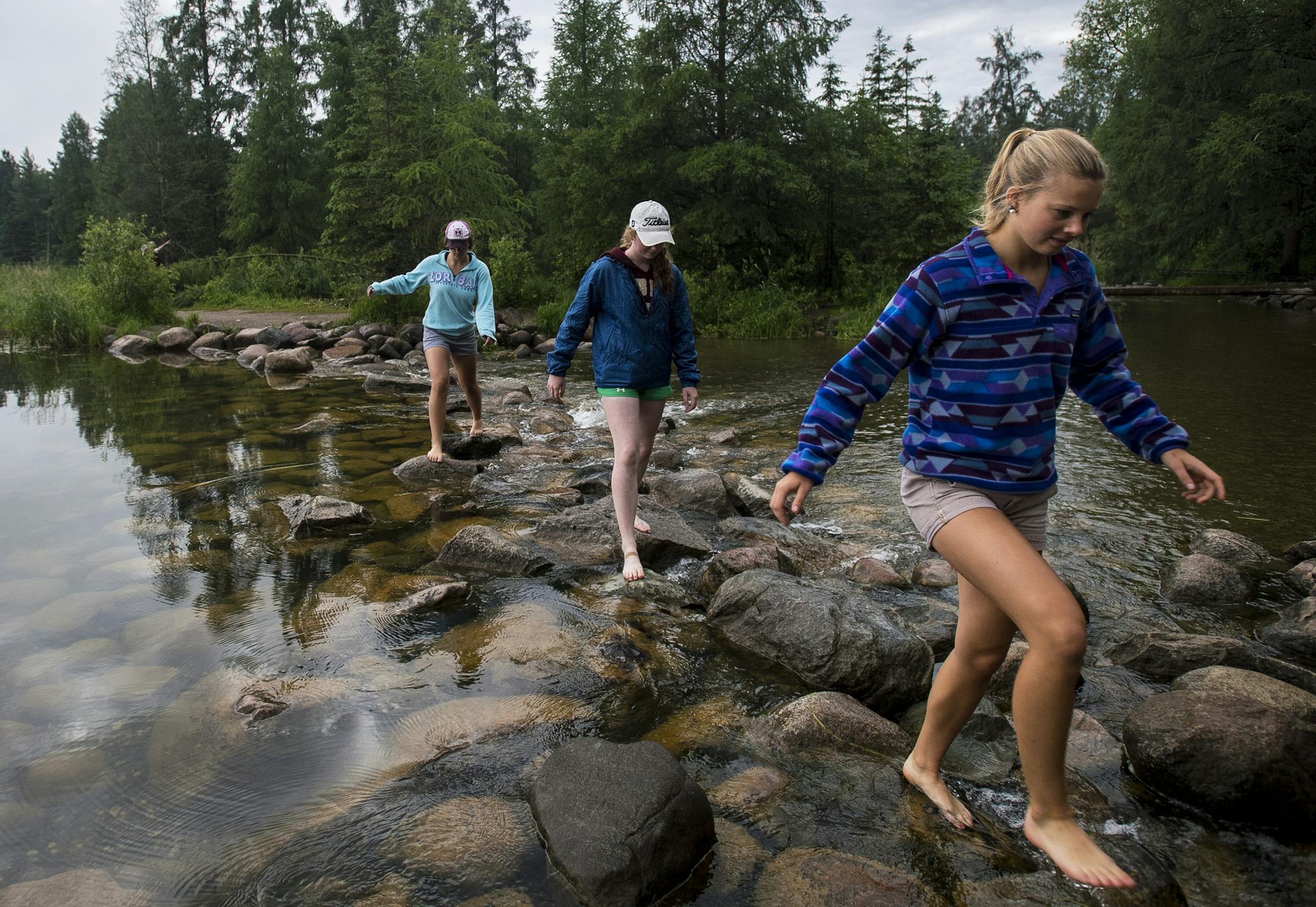 Emma Daniels, right, Abby MacFarlane and Marie Preston, back, walked across the rocks at the headwaters of the Mississippi at Lake Itasca in mid June. The high school seniors were visiting from Fergus Falls. ] (AARON LAVINSKY/STAR TRIBUNE) aaron.lavinsky@startribune.com RIVERS PROJECT: We look at three of Minnesota's rivers, including the Mississippi, Red and Chippewa, to see how land use effects water quality and pollution.