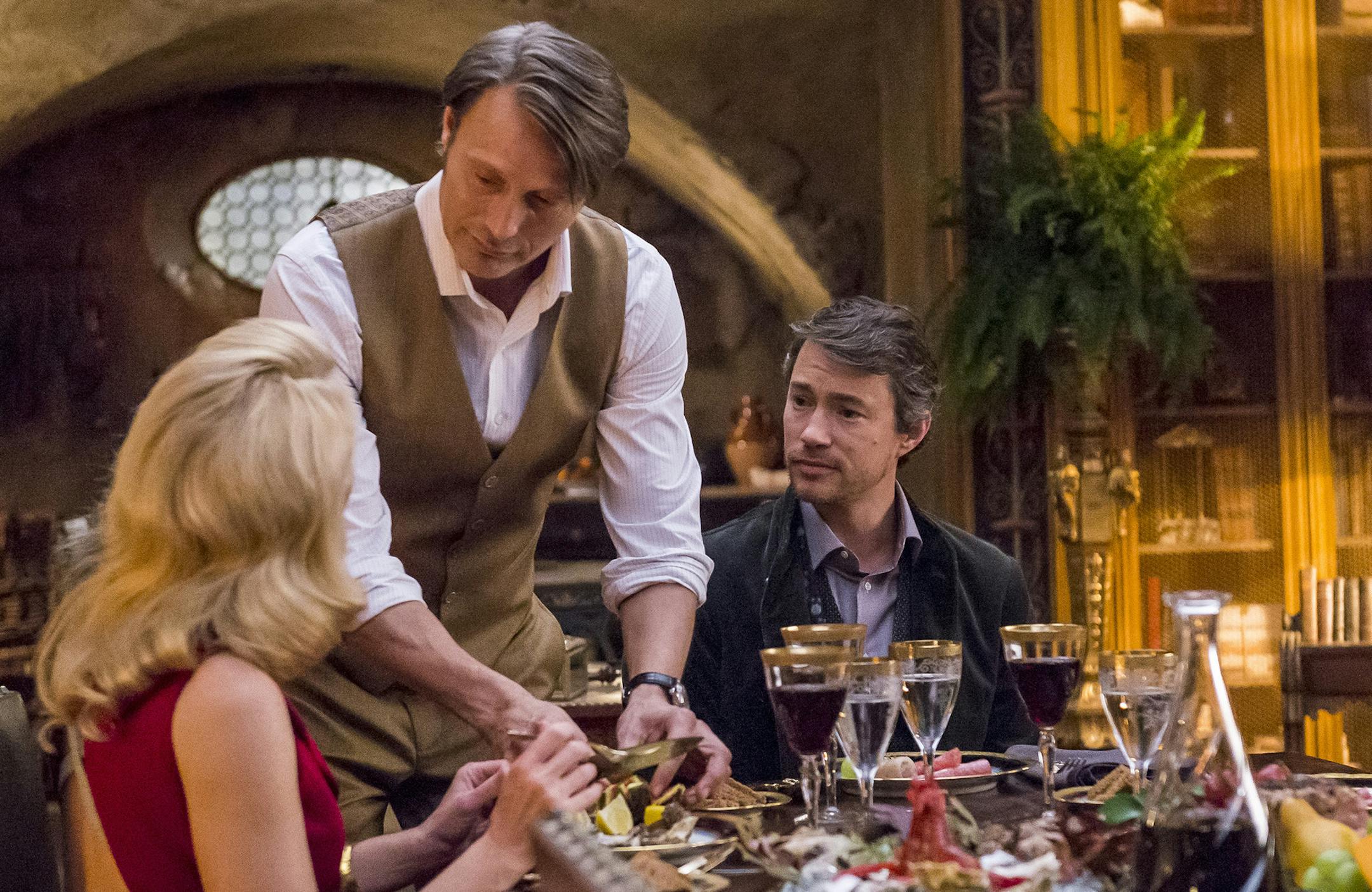 "Antipasto" Episode 301 -- Pictured: (l-r) Gillian Anderson as Dr. Bedelia Du Maurier, Mads Mikkelsen as Dr. Hannibal Lecter, Tom Wisdom as Anthony Dimmond in the Season 3 premiere of "Hannibal"-- (Photo by: Brooke Palmer/NBC) ORG XMIT: Season:3