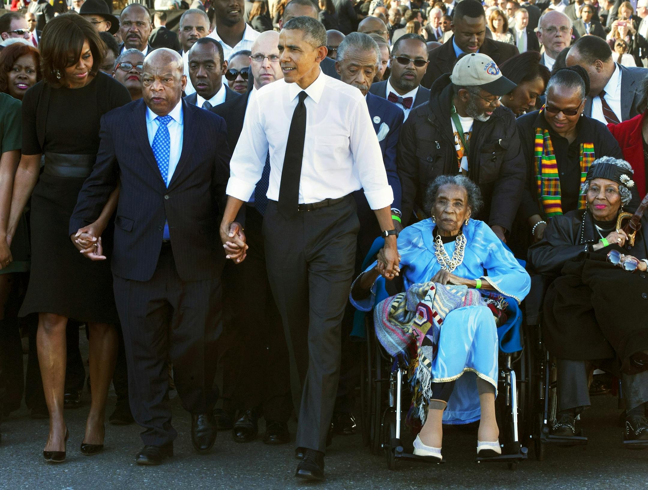 FILE - In this March 7, 2015 file photo, President Barack Obama, center, holds hands with Rep. John Lewis, D-Ga., left, and Amelia Boynton Robinson, right, who were both beaten during "Bloody Sunday," as they walk across the Edmund Pettus Bridge in Selma, Ala., for the 50th anniversary of ìBloody Sunday." Boynton Robinson, a civil rights activist who nearly died while helping lead the Selma march on ìBloody Sunday,î championed voting rights for blacks, and was the first black woma