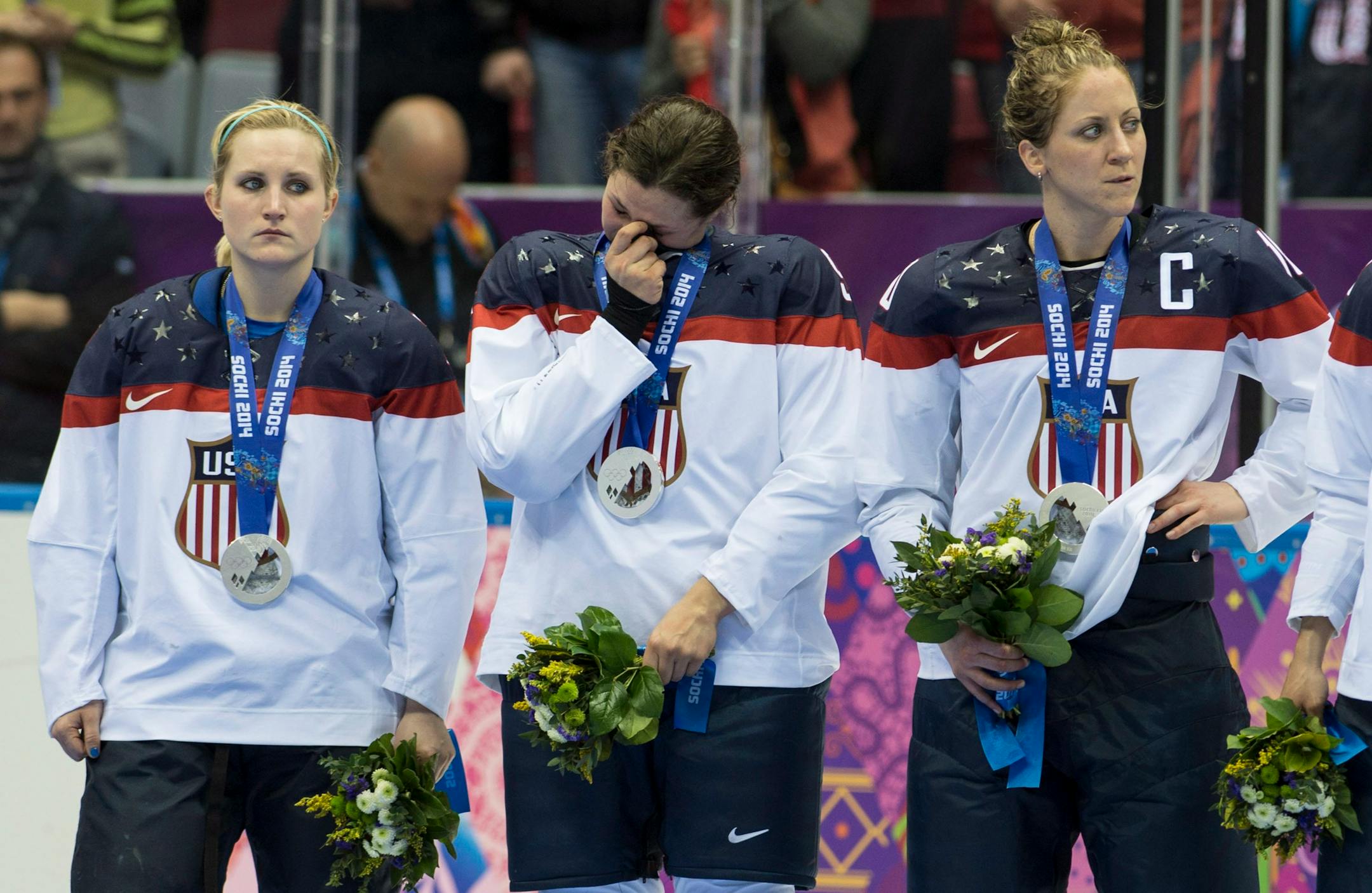USA's Monique Lamoureux, Megan Bozek and Meghan Duggan, left to right, react after losing 3-2 in overtime to Canada to win the silver medal in the women's hockey final at the Sochi Winter Olympics, Thursday, Feb. 20, 2014 in Sochi. (AP Photo/The Canadian Press, Paul Chiasson)