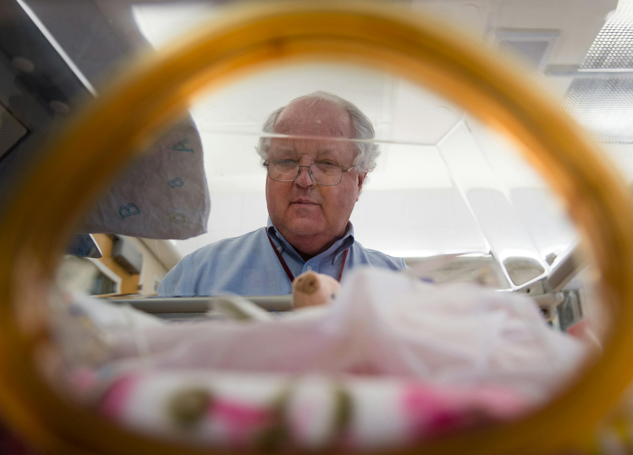 Dr. William Benitz peers into the incubator of a premature baby at the neonatal intensive-care unit at Lucile Packard Children's Hospital in Palo Alto, Calif., on Oct. 20, 2015. (Heidi de Marco/Kaiser Health News/TNS)