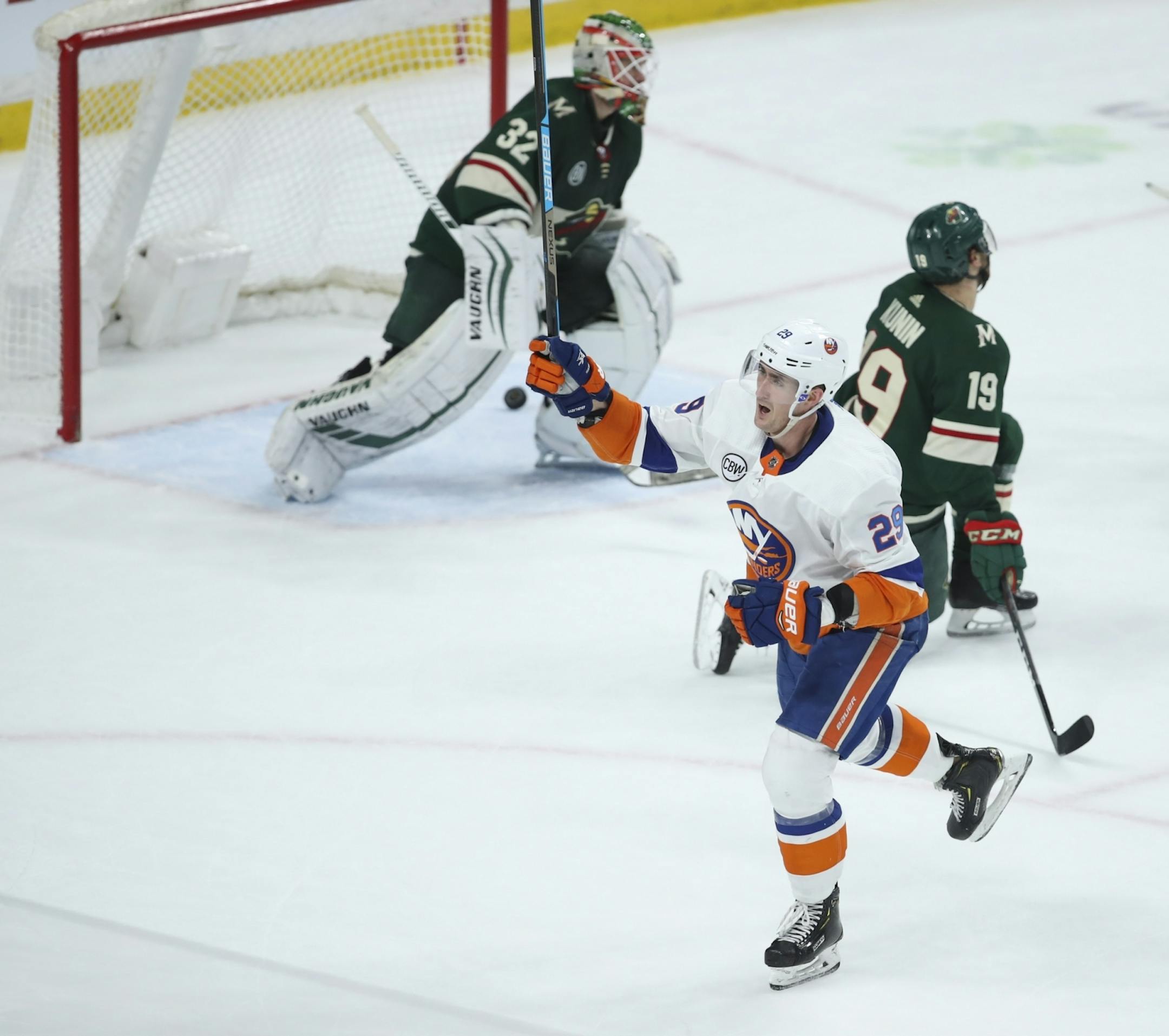 New York Islanders center Brock Nelson (29) celebrated after he scored the game winner on a wrist shot in overtime on Wild goaltender Alex Stalock (32) with center Luke Kunin (19) defending.