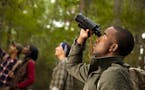Group of friends camping and hiking using binoculars . istock