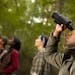 Group of friends camping and hiking using binoculars . istock
