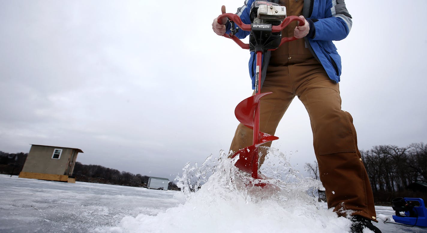 Joel Rebney, 33 of Burnsville drilled a hole in the ice before fishing at Upper Prior Lake on Tuesday afternoon. ] CARLOS GONZALEZ cgonzalez@startribune.com, January 27, 2015, Prior Lake, Minn., Outdoors Weekend story is about south metro and south-state ice fishing