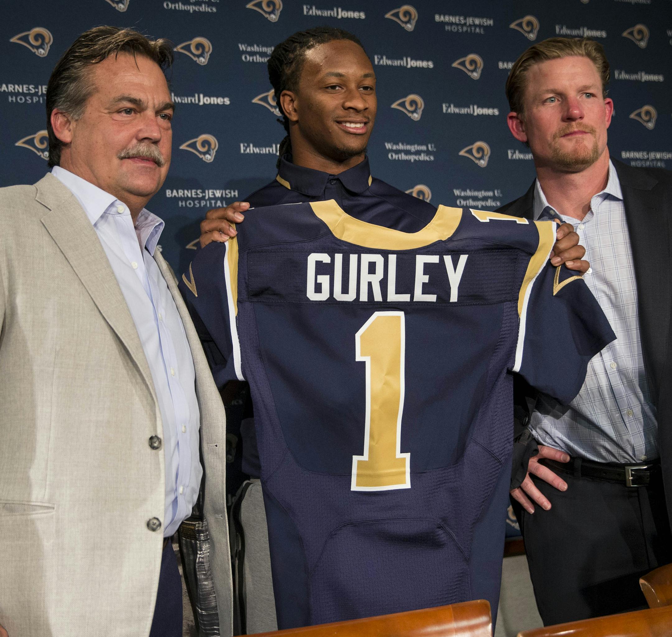 St. Louis Rams head coach Jeff Fisher, left, and general manager Les Snead, right, introduce first-round draft pick Todd Gurley during a news conference at the NFL football team's practice facility Friday, May 1, 2015, in St. Louis. Gurley, a running back from Georgia, was picked tenth overall by the Rams. (AP Photo/Whitney Curtis)