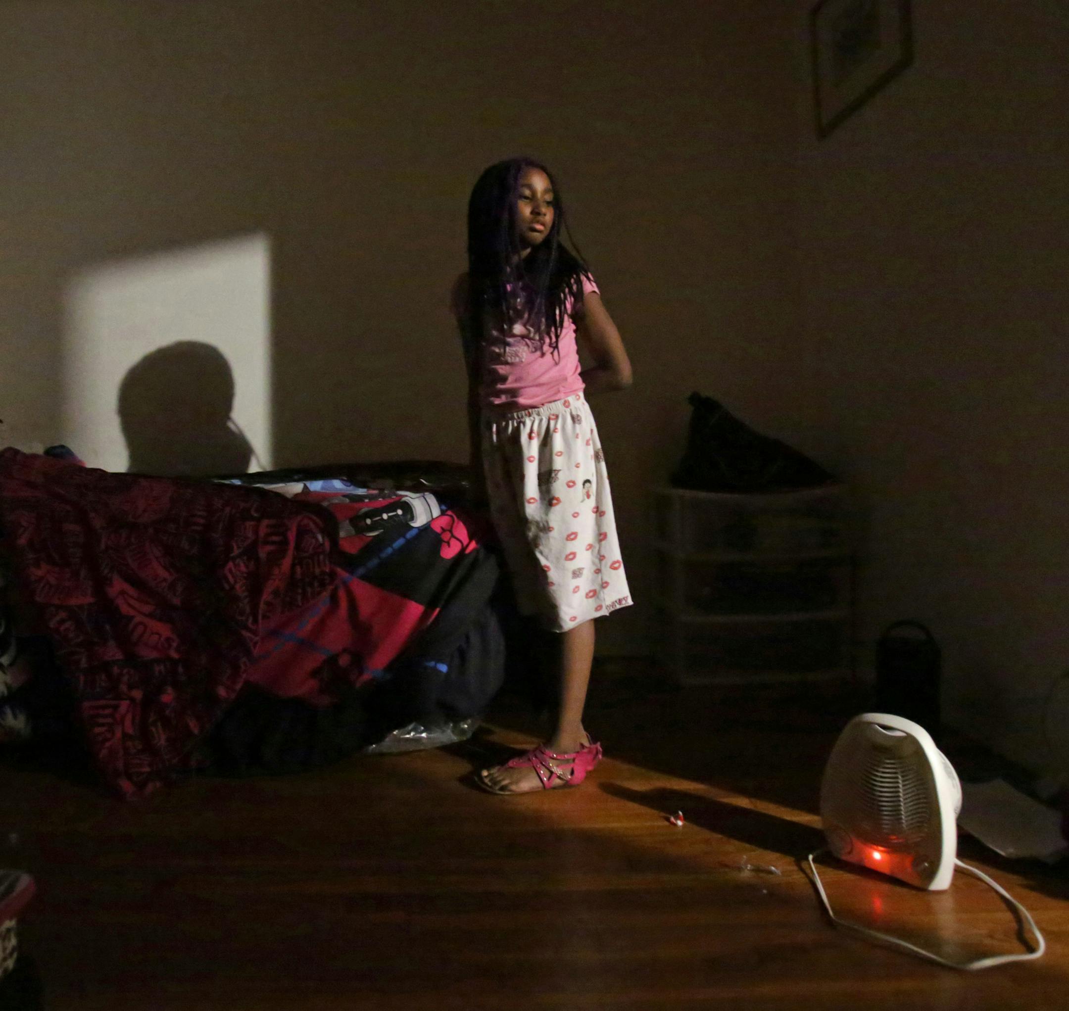 Akeelah Kelly, 8, pauses before going to bed on Sunday, Nov. 22, 2015. The family has been without gas heat since September. They use electric space heaters to warm their home on Ellison Drive in Ferguson, Mo. They were also without electricity in September due to delinquent utility bill. (Laurie Skrivan/St. Louis Post-Dispatch/TNS)