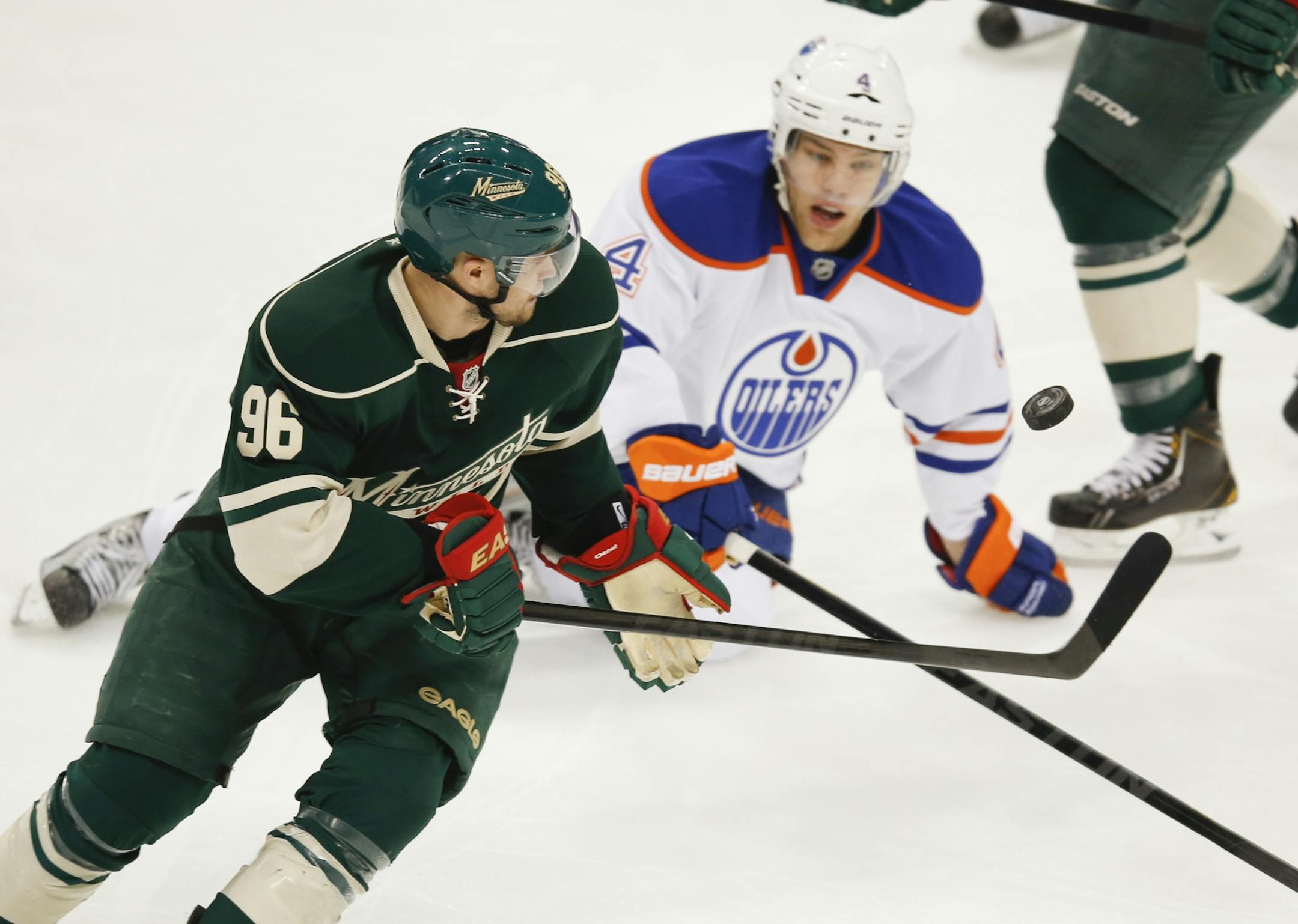 The Edmonton Oilers Taylor Hall (4) battles the Minnesota Wild's Pierre Marc Bouchard (96) for the puck during first period action Friday, April 26, 2013, at the Xcel Energy Center in St. Paul, MN.