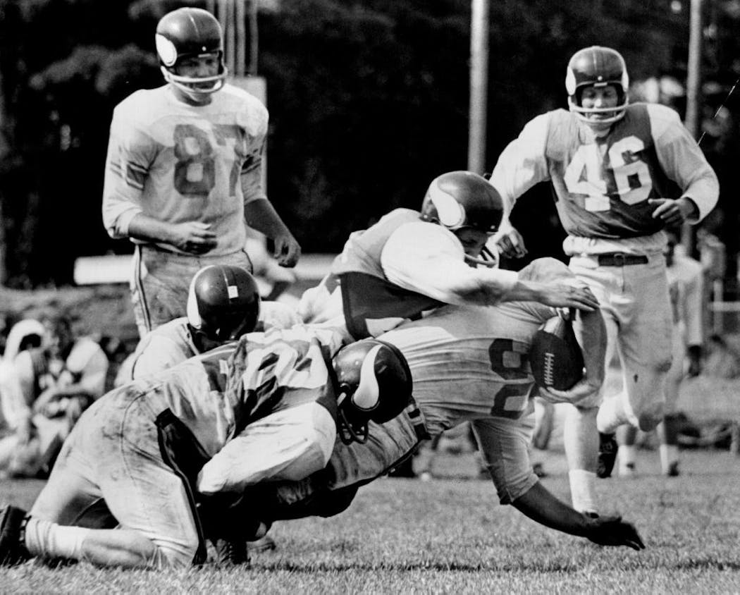 Vikings fullback Bill Brown is tackled during a scrimmage in Bemidji during training camp in 1963.