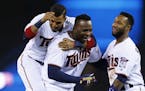 Minnesota Twins' Eddie Rosario, left, and Danny Santana, right, welcome Miguel Sano after his walk-off single gave the Twins a 6-5 win over the Clevel
