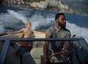 This image released by Warner Bros. Entertainment shows Elizabeth Debicki, left, and John David Washington in a scene from "Tenet." As "Tenet" enters 