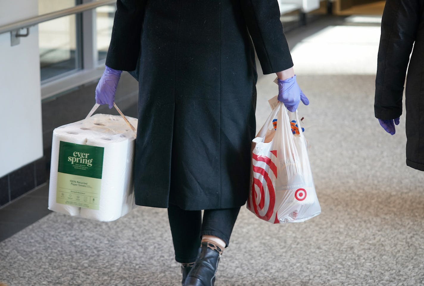 A rubber-gloved shopper carried paper towels and other supplies through the downtown Minneapolis skyway Tuesday.