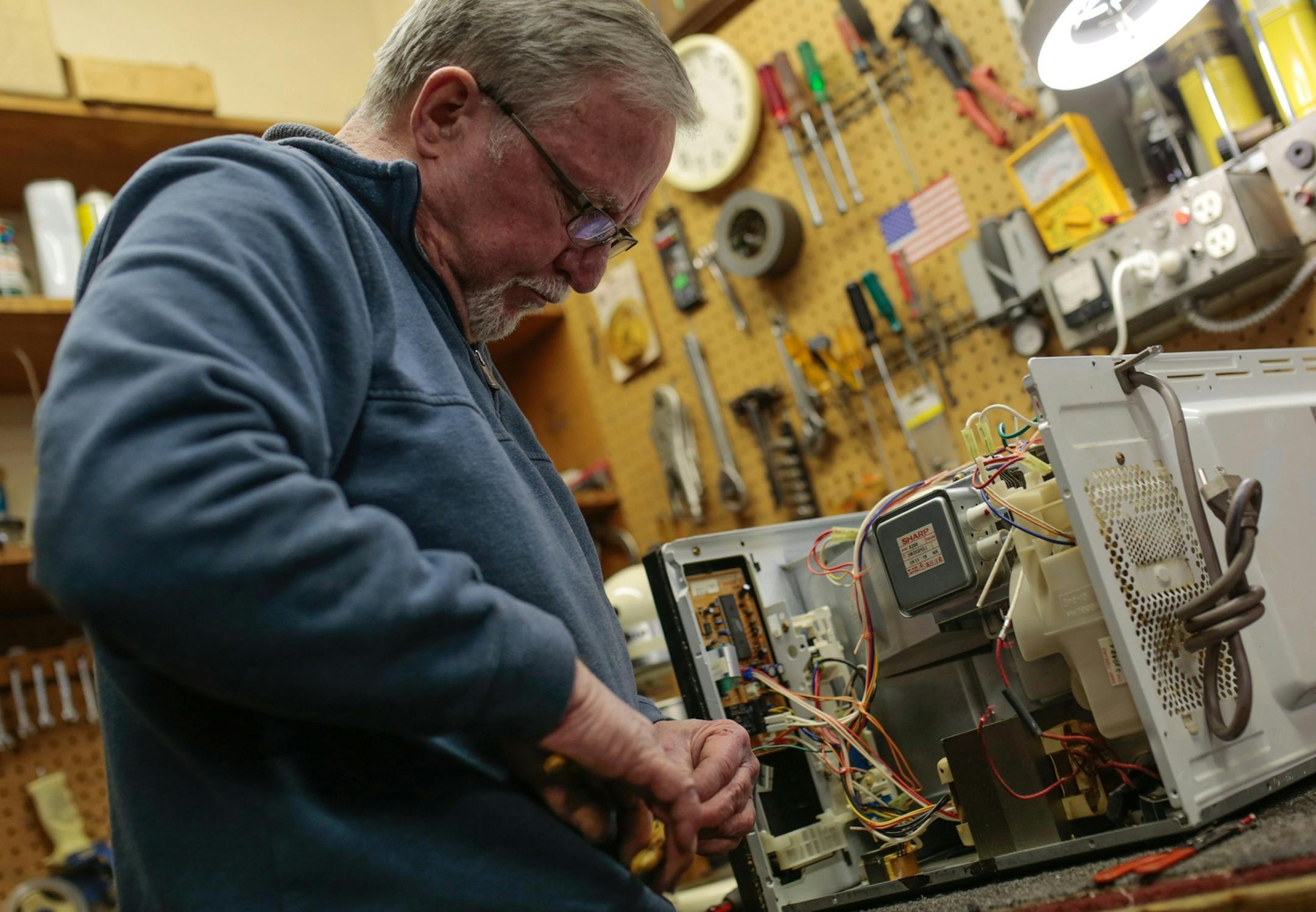 McNichols Electric co-owner Dave Kehoe works on fixing a microwave at his small appliance repair shop on Detroit's west side on Tuesday, March 20, 2018. (Ryan Garza/Detroit Free Press/TNS) ORG XMIT: 1228110