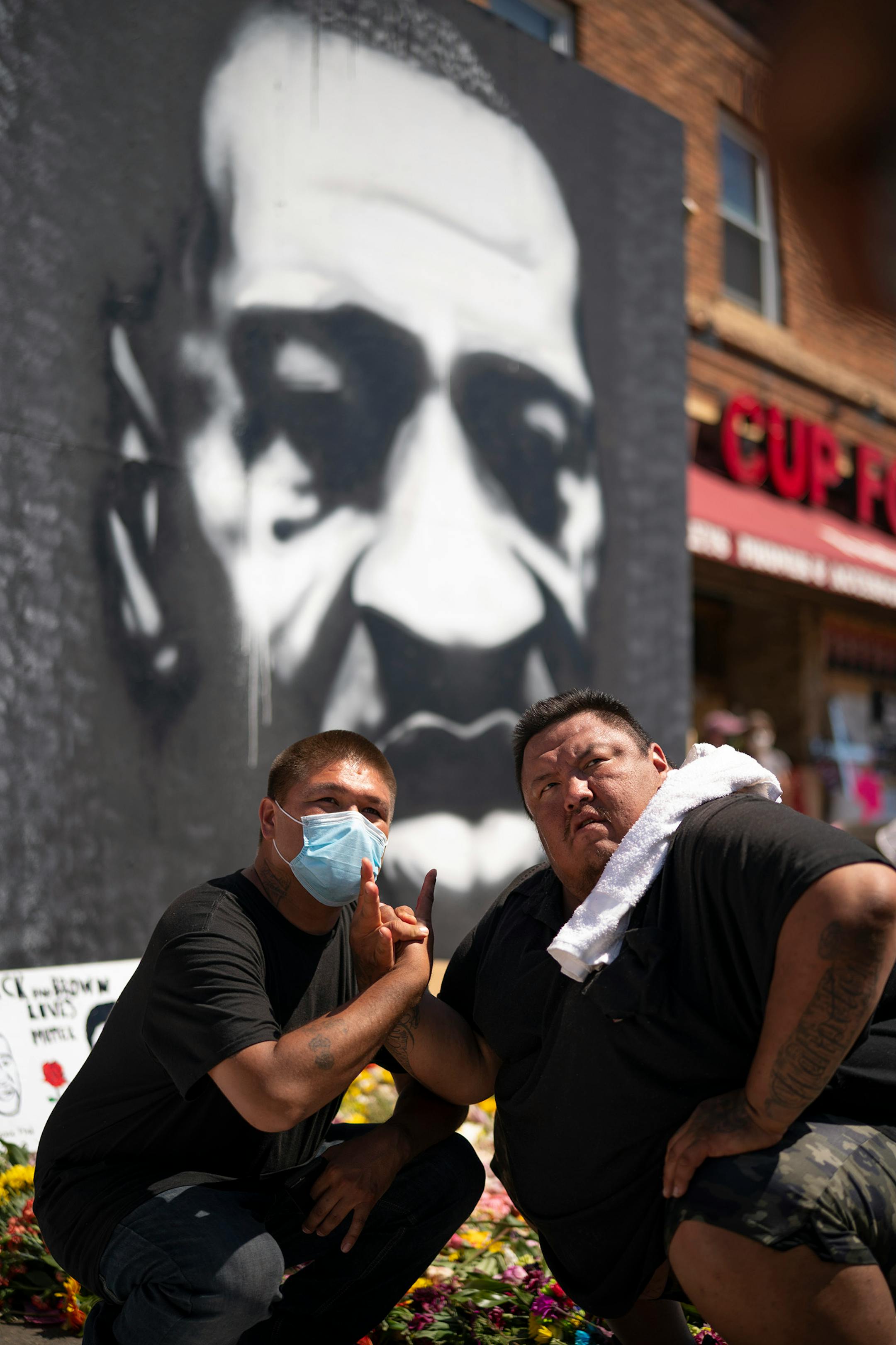 Galan Renville, left, and Stacy Brant Jr. posed for a photo by a friend after they and other Native Americans from Sisseton, S.D. performed in a drum circle at the memorial to George Floyd on Sunday, June 7, in Minneapolis.