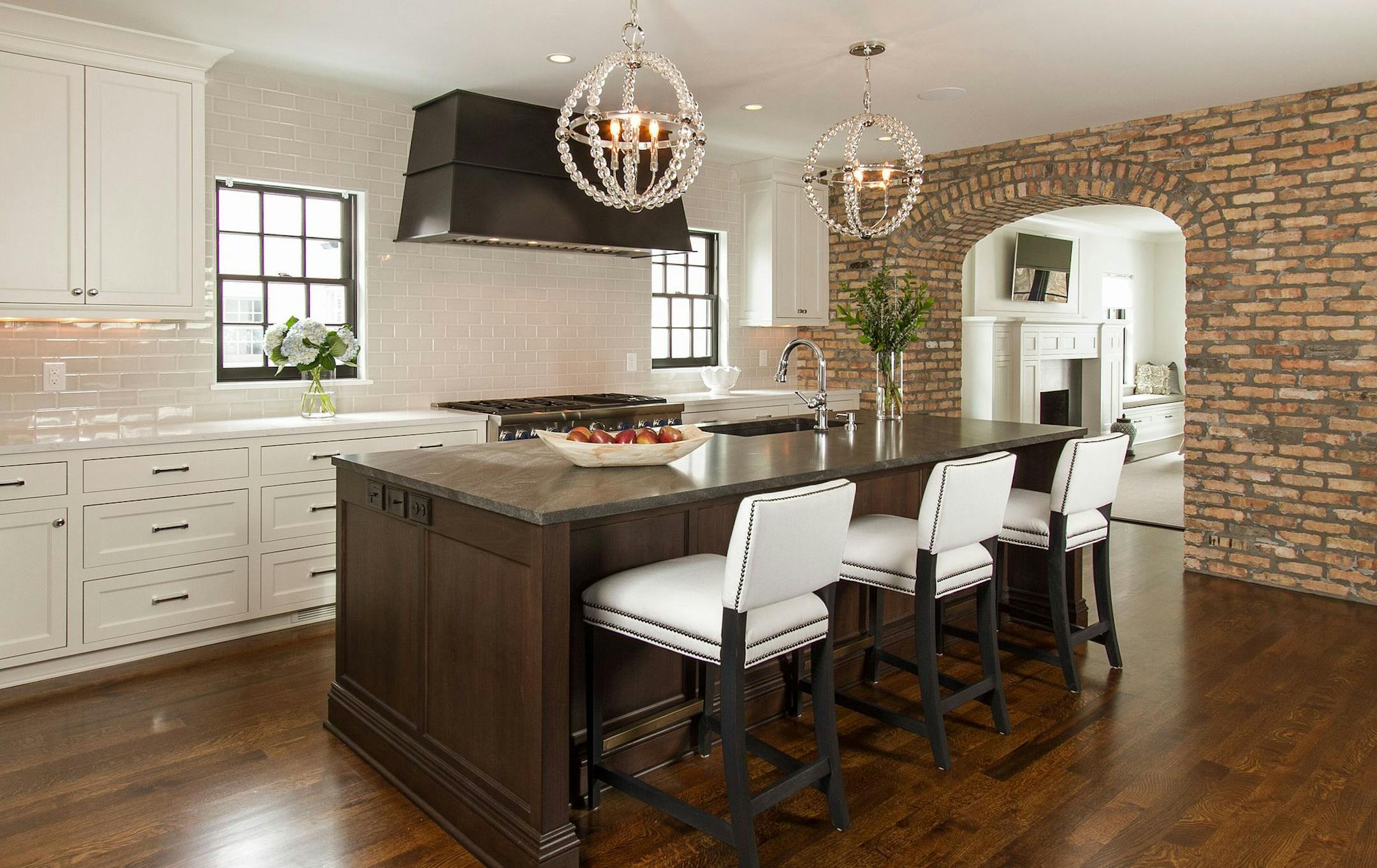 The new kitchen features an island of alder wood topped with honed granite. The arch to the dining room is clad in Chicago brick.