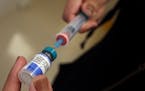 A vial containing the MMR vaccine is loaded into a syringe before being given to a baby at the Medical Arts Pediatric Med Group in Los Angeles on Febr