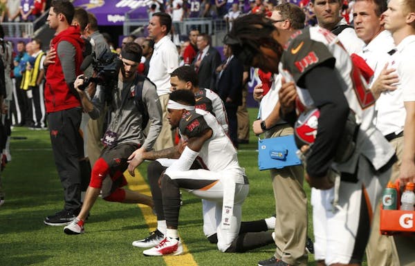 Tampa Bay Buccaneers wide receiver DeSean Jackson, center, takes a knee during the national anthem before an NFL football game against the Minnesota V