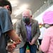 Gov. Tim Walz hands challenge coins to Jackson, 9, and Makenna Spiekermeier, 5, after they received a dose of a COVID-19 vaccine Thursday at Century C