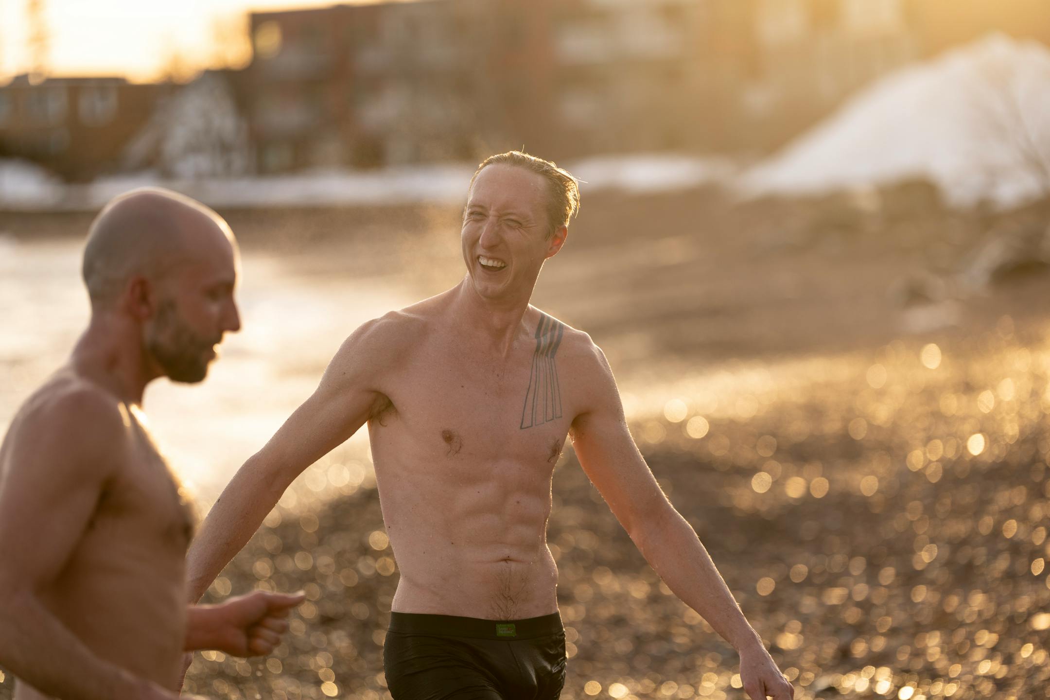 Sven Hoaglund and Shaun Tudor run out of the chilly water while taking a dip in Lake Superior after sitting in a sauna at Sisu and Löyly Sauna.