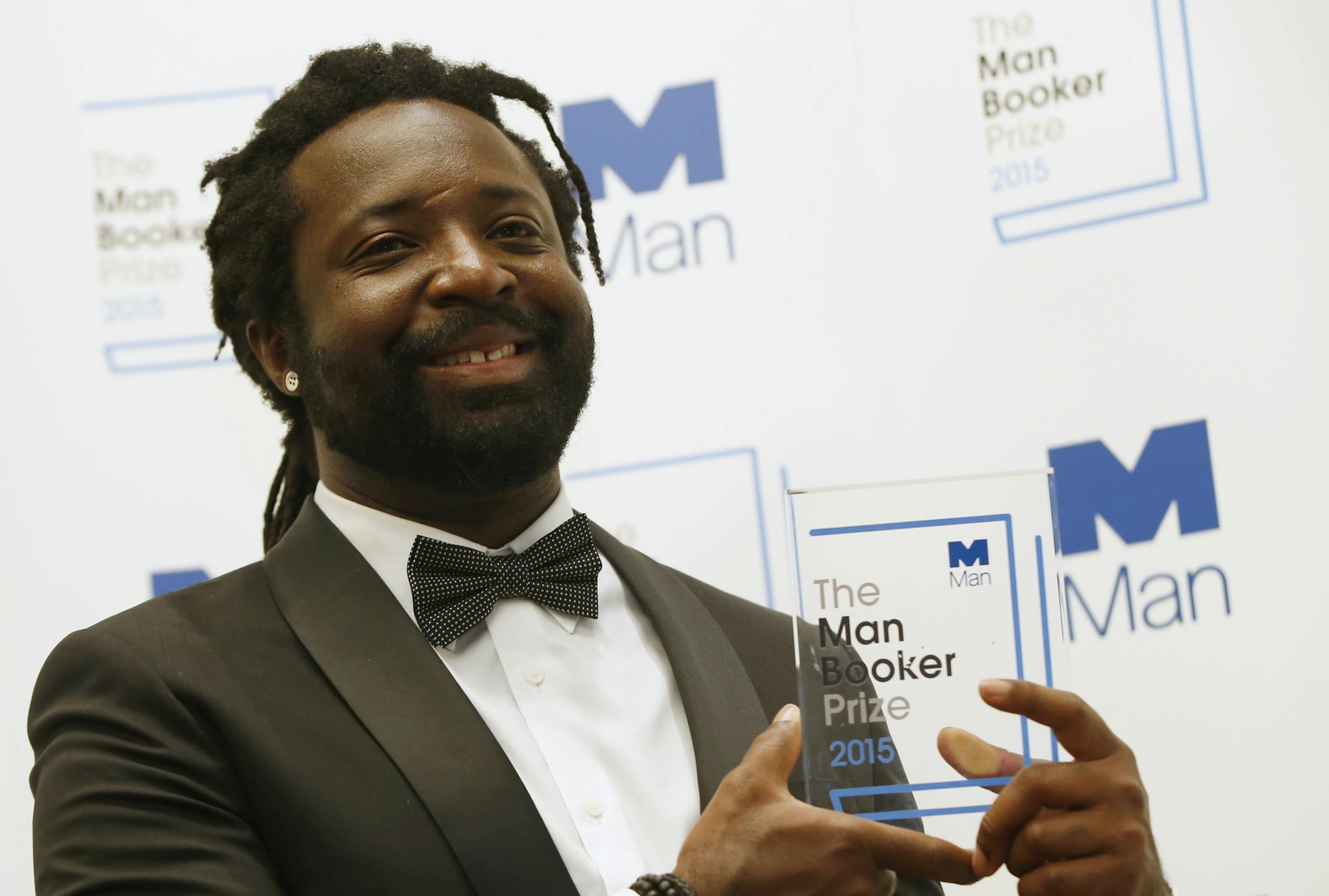 FILE - In this Oct. 13, 2015 file photo, Jamaican author Marlon James poses with the award after his book "A Brief History of Seven Killings," was named as winner of the 2015 Booker Prize 2015 for Fiction in London. Author of four novels, the 48-year-old James has made an art of “finding what would rather stay lost,” as he writes in his new work, “Black Leopard, Red Wolf.” (AP Photo/Alastair Grant, File)