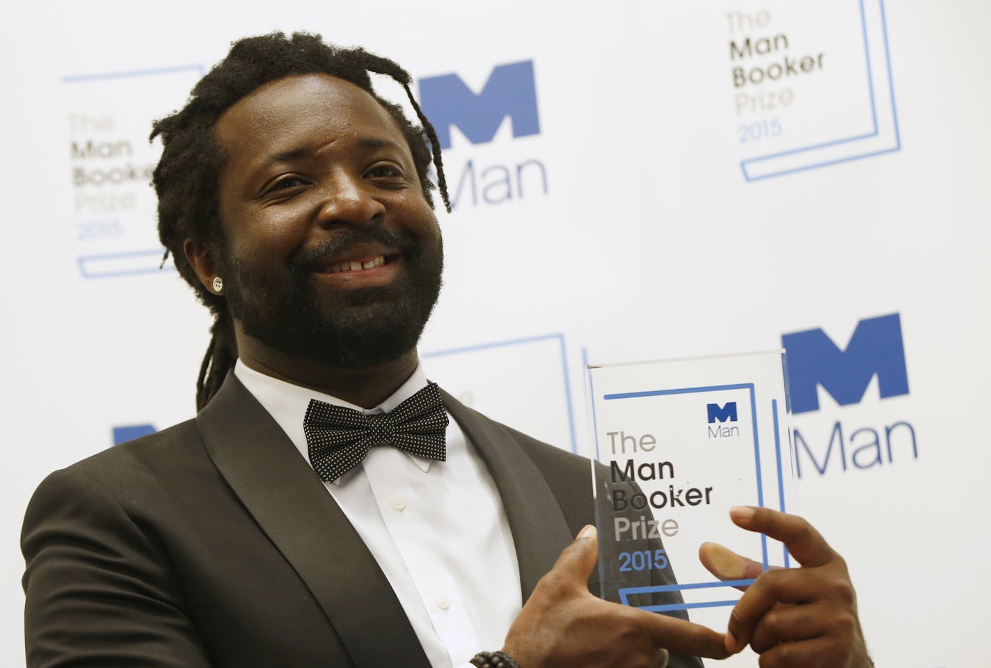 FILE - In this Oct. 13, 2015 file photo, Jamaican author Marlon James poses with the award after his book "A Brief History of Seven Killings," was named as winner of the 2015 Booker Prize 2015 for Fiction in London. Author of four novels, the 48-year-old James has made an art of &#x201c;finding what would rather stay lost,&#x201d; as he writes in his new work, &#x201c;Black Leopard, Red Wolf.&#x201d; (AP Photo/Alastair Grant, File)