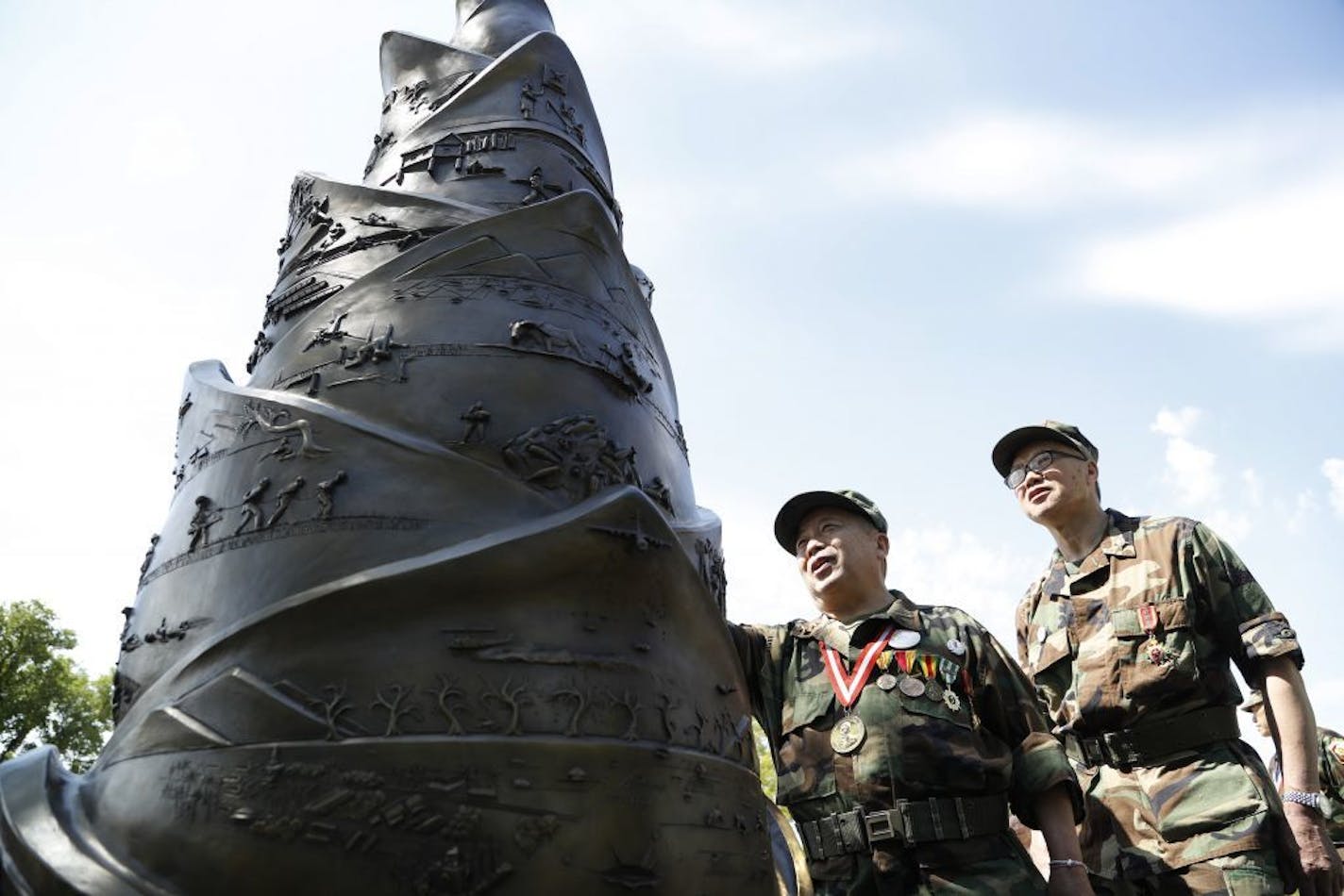 Lieutenant Xai Vang left and Cheng Vang looked over the monument during a service at the Hmong/Lao Veteran Statue to honor and remember those who died fighting for American causes in Laos at the state capitol Sunday May 14, 2017 in St. Paul, MN.