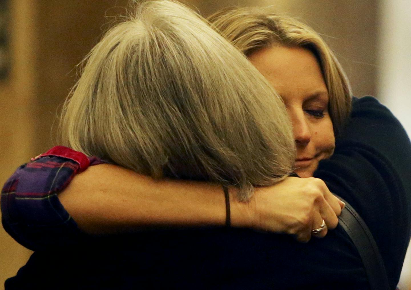 In this Sept. 19, 2013, file photo, family members of Kira Steger hug while waiting for an elevator to take them to the courtroom for the start of the murder trial of Jeffrey Trevino, Kira's husband, at the Ramsey County Courthouse in St. Paul.