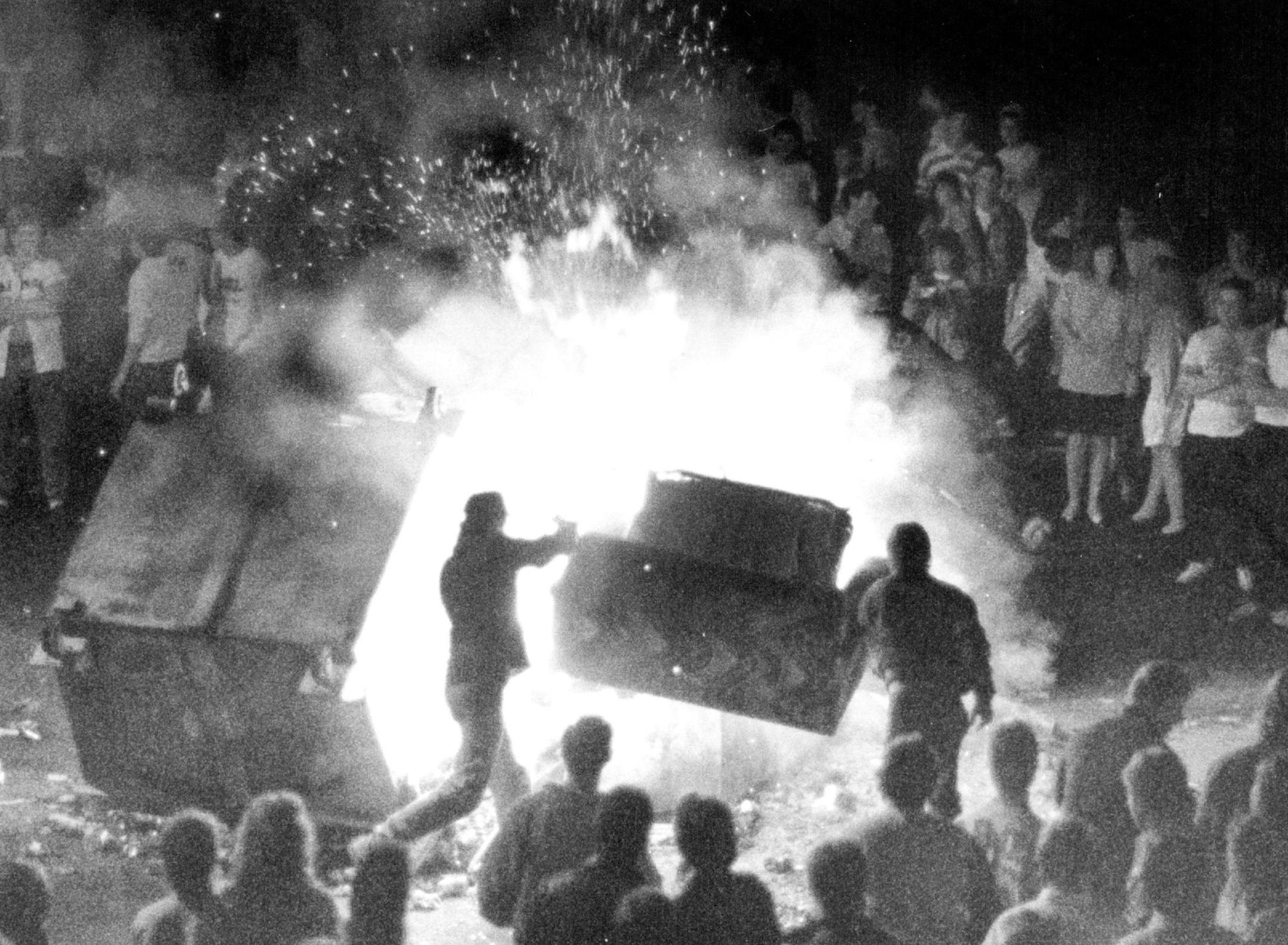 October 15, 1988 Students on the Campus of St. Cloud State University, light a fire in the middle of the street and throw in anything they could find to fuel the fire and the riot like party. Here students throw a hide-a-bed couch into the fire. Also thrown into the fire were doars from near by houses, street signs. and explosives like shotgun shells, spray cans and a fire extinguisher. The fire lasted from about 12;30 a.m. till about 4 a.m. when police in riot gear came in and broke up the part