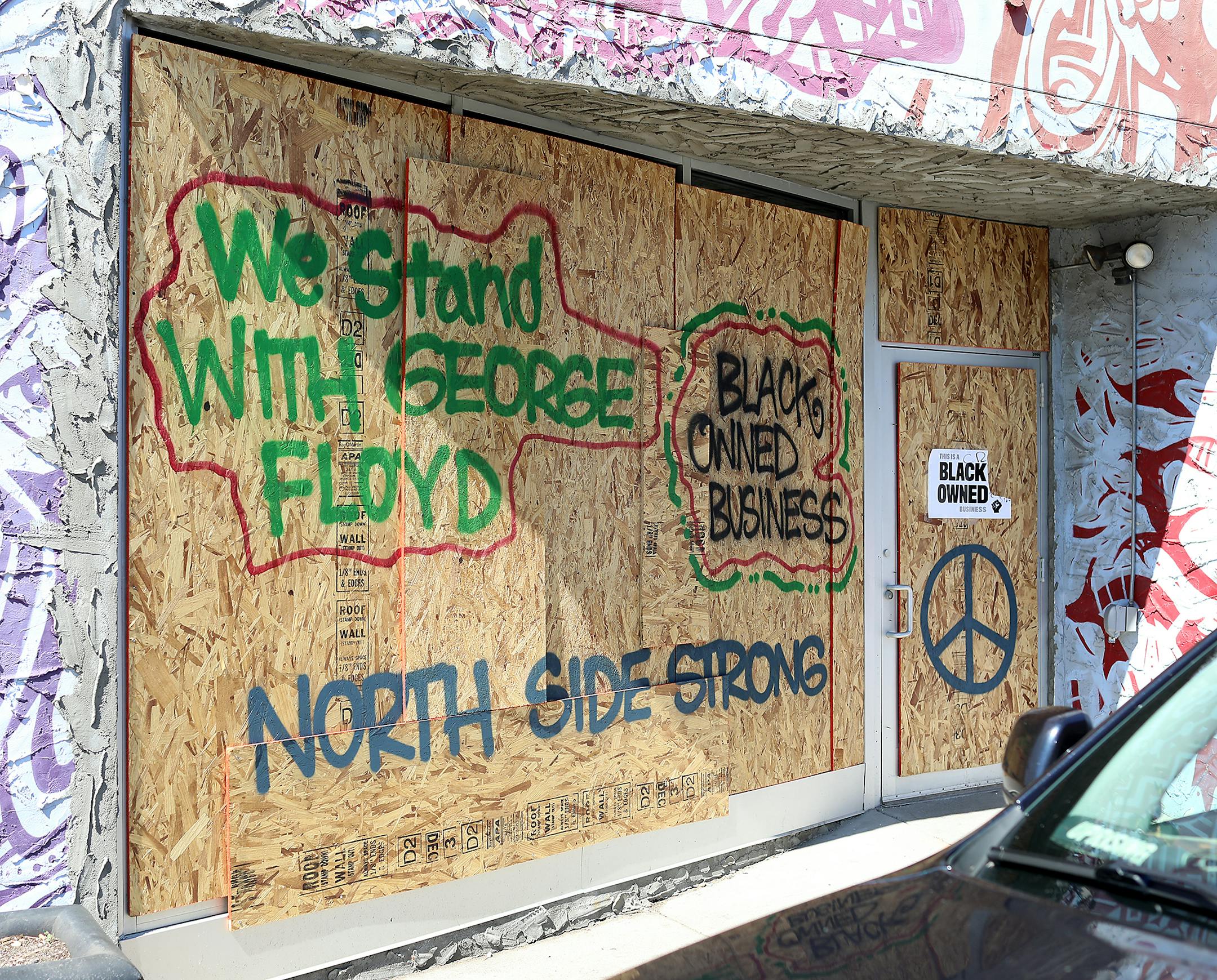 Messages of solidarity and pride for black-owned business cover the boarded-up windows and doors of Juxtaposition Arts' 1108 West Broadway building in north Minneapolis.