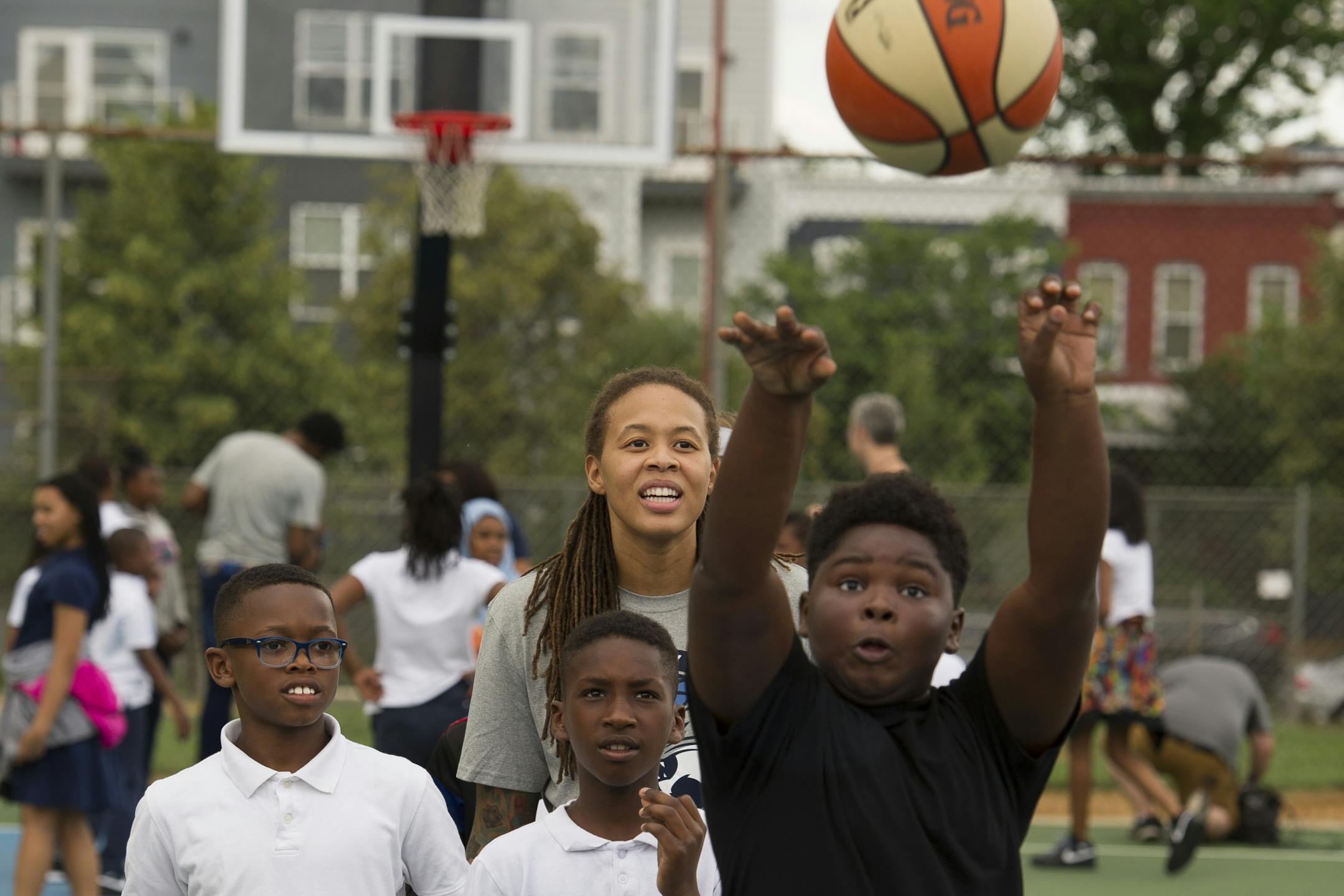 WNBA Champion Minnesota Lynx guard Seimone Augustus, center watches as a student makes a free throw at Payne Elementary School in Washington, Wednesday, June 6, 2018. Payne Elementary has the highest homeless student population in the district.