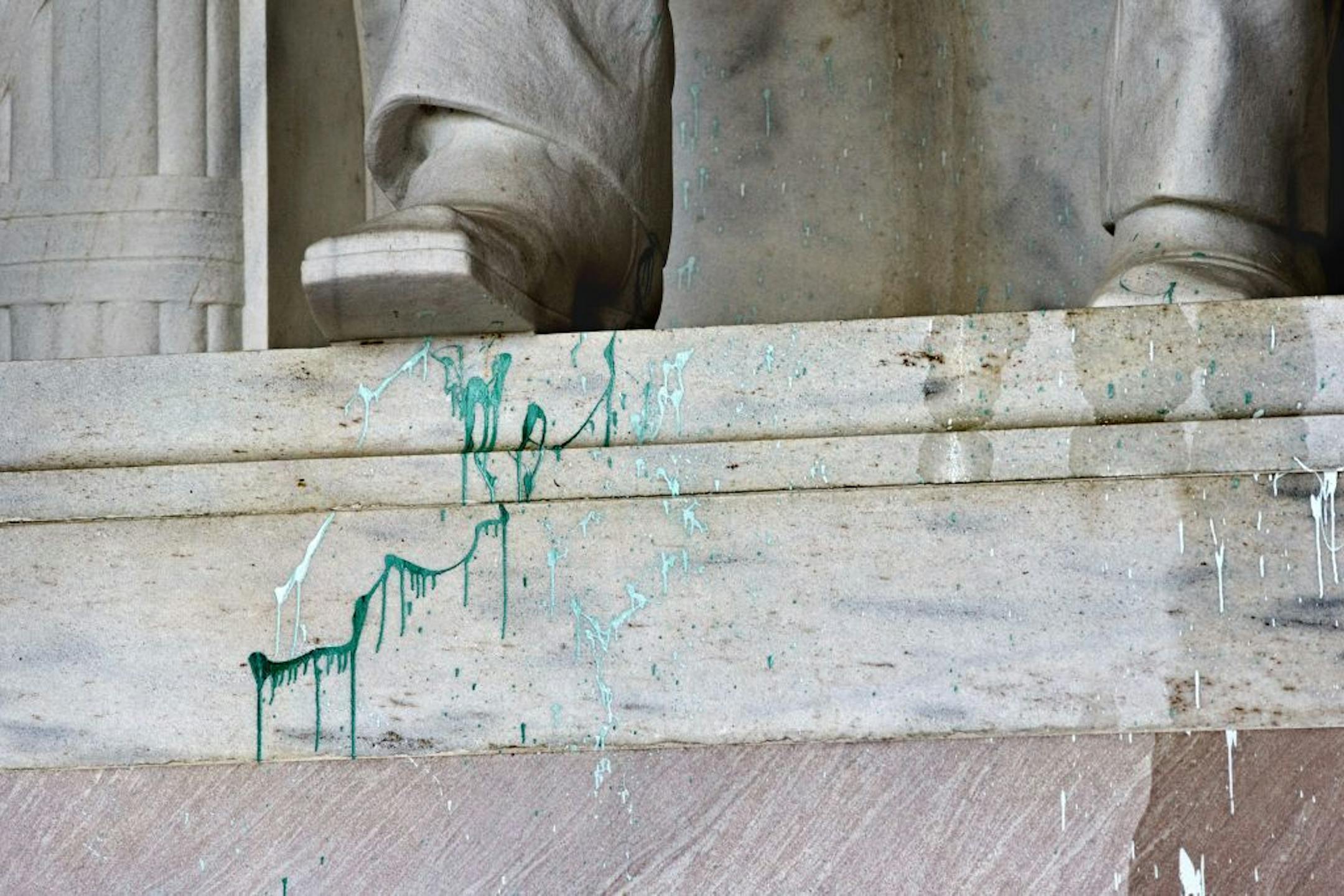 Green paint is splattered on the base of the statue of Abraham Lincoln at the Lincoln Memorial in Washington, Friday, July 26, 2013. Police say the apparent vandalism was discovered early Friday morning with no words, letters or symbols visible in the paint.