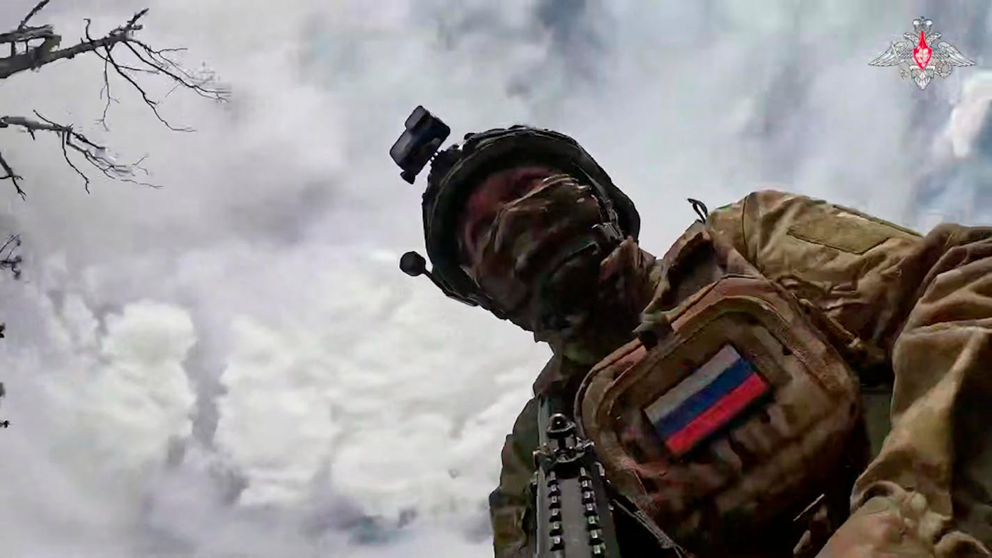 Photo taken from below of soldier in camouflage uniform and helmet with tech features