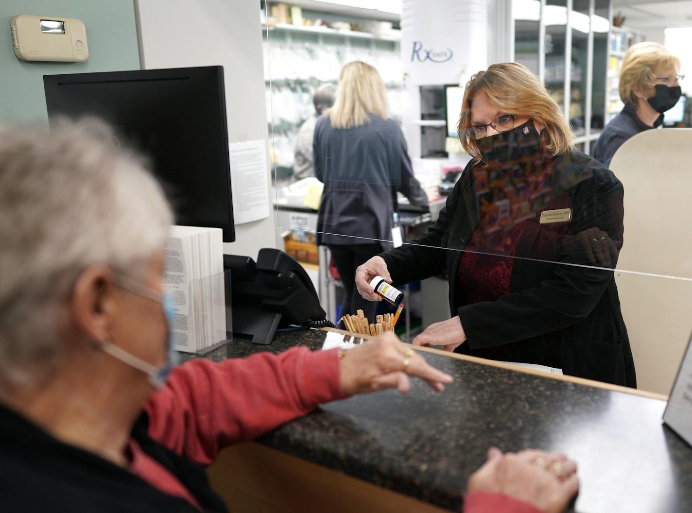 Deborah Keaveny, pharmacist at Keaveny Drug in Winsted, Minn., fills a prescription for Ruth, a longtime customer. Small, independent pharmacies are closing in record numbers in Minnesota.