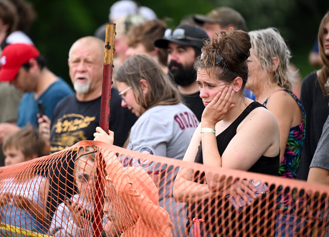 Melissa Peters of St. Peter watches in disbelief as water rushes over the Rapidan Dam on Monday. “I’m really sad to see it potentially go,” said Peters, who is also concerned about flooding in her hometown. 