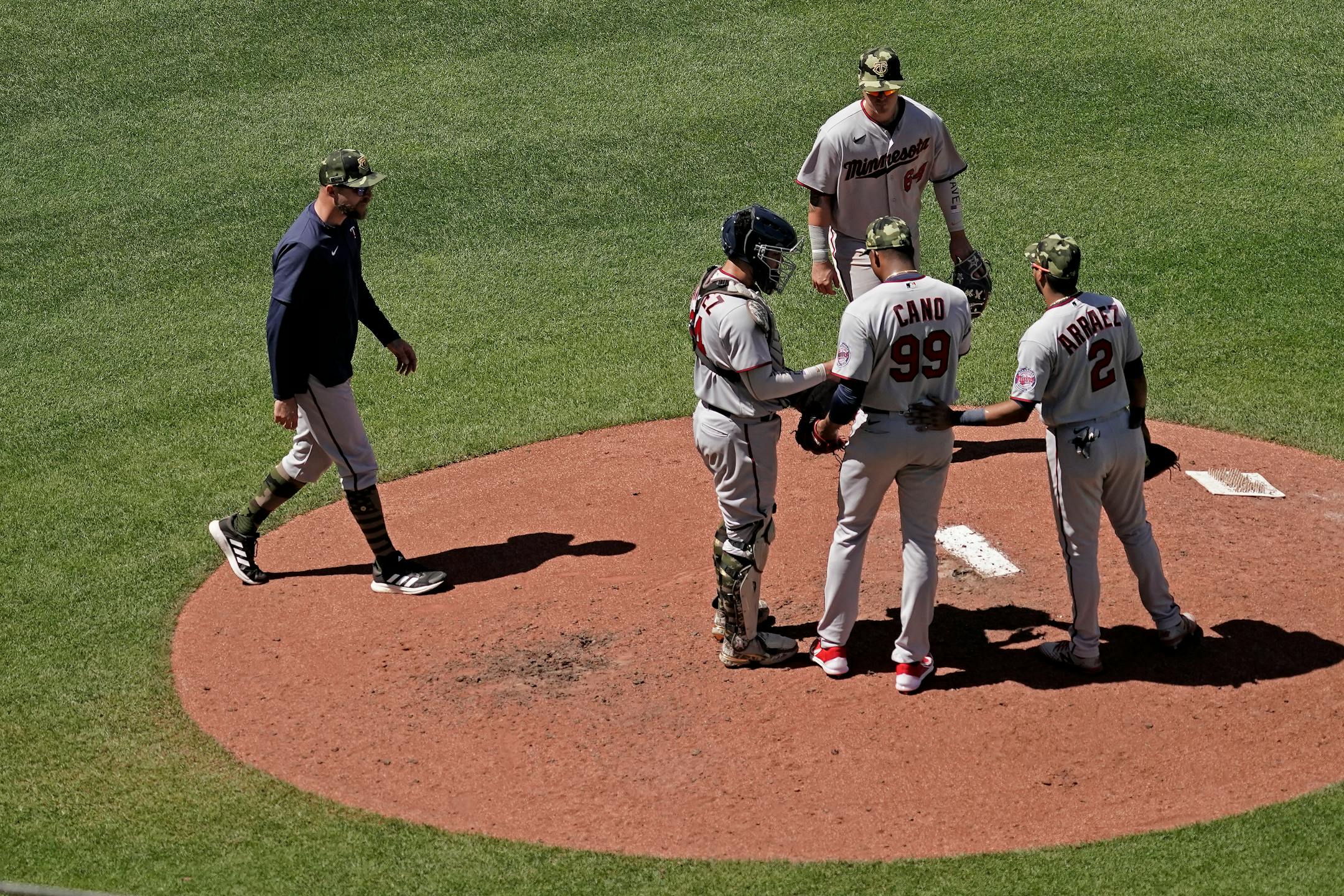 Minnesota Twins manager Rocco Baldelli, left, walks to the mound to make a pitching change during the sixth inning of a baseball game against the Kansas City Royals Sunday, May 22, 2022, in Kansas City, Mo. (AP Photo/Charlie Riedel)