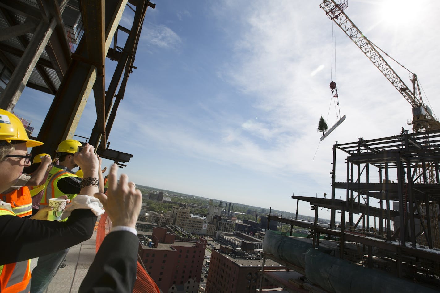 Invited guests watch and take photos from the 15th floor during a topping off ceremony for the new Wells Fargo towers by Ryan Companies in Minneapolis on Tuesday, June 2, 2015.